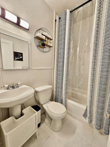 a white bathroom with a toilet and a sink at Cute stay in Memphis in Memphis