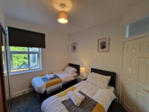 1 dormitorio con 2 camas y ventana en Swanley Guest House en Kent