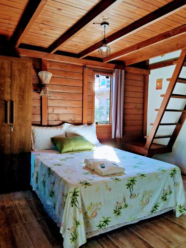 a bedroom with a large bed with a wooden ceiling at Chalés Praia do Rosa piscina compartilhada in Imbituba