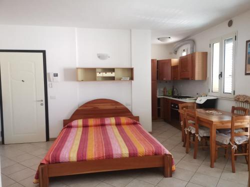 1 dormitorio con cama, mesa y cocina en Marechiaro, en Rímini