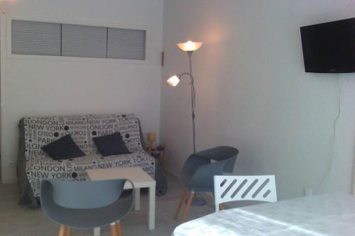 un salon avec un lit, une table et des chaises dans l'établissement APPARTEMENT P2 + CABINE LE GRAU DU ROI, au Grau-du-Roi