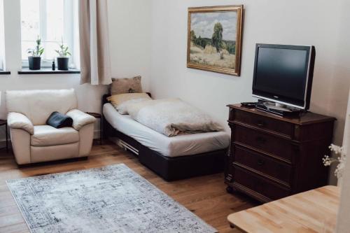 a small living room with a couch and a tv at Gemütliches Gästezimmer in Eickeloh
