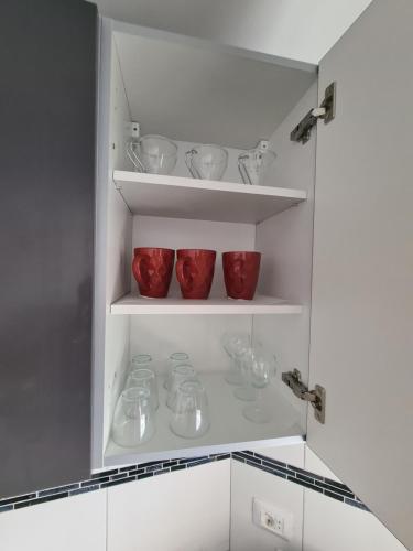 a kitchen with red bowls and glasses on shelves at summerland beach in Los Cristianos