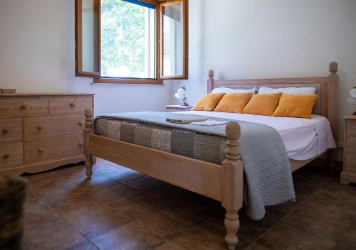 a bedroom with a bed with orange pillows and a window at Perla Marina in Marina di Modica