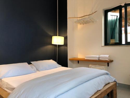 a bedroom with a large white bed with a window at Casa Mamma Bruna in San Vito lo Capo