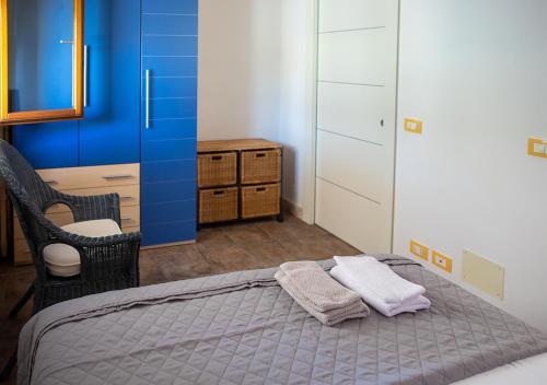 a bedroom with a bed with two towels on it at Perla Marina in Marina di Modica