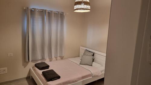 un piccolo letto con due asciugamani sopra in una stanza di adii villa a Baraq