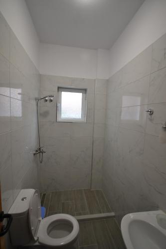 a bathroom with a toilet and a sink at Little Cozy Apartment 1 in Sarandë