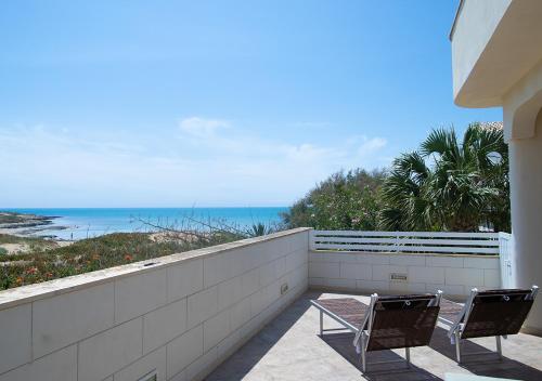 two chairs sitting on a balcony overlooking the ocean at Perla Marina in Marina di Modica