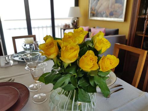 a vase filled with yellow roses on a table at La Stanza dei Sogni in Saluzzo