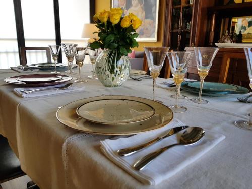 a table with a plate and a vase of yellow flowers at La Stanza dei Sogni in Saluzzo