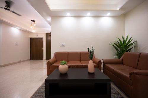 a living room with two brown couches and a coffee table at Lakeside Suites in Kolkata