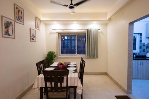 a dining room with a table and chairs and a window at Lakeside Suites in Kolkata