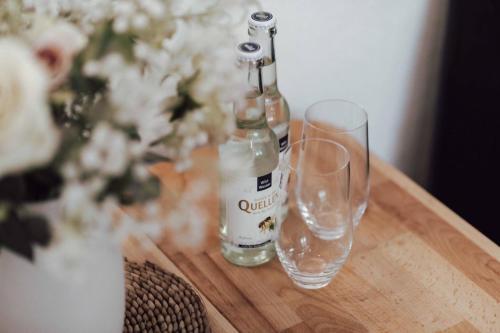 a wooden table with two bottles and glasses on it at Gemütliches Gästezimmer in Eickeloh