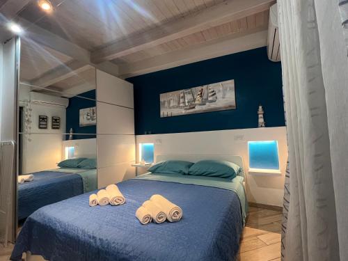 two beds in a room with blue walls at Spegni La Luce b&b in Agropoli