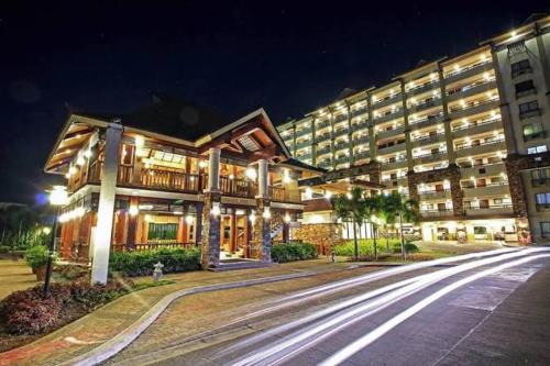a large building with lights on a street at night at Cozy Condo in Pasig City- Bali Oasis 2 in Manila