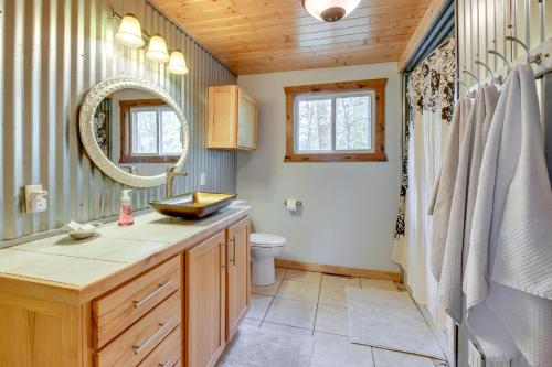 a bathroom with a sink and a toilet and a mirror at Minnesota Cabin with Deck and Private Beach in Merrifield