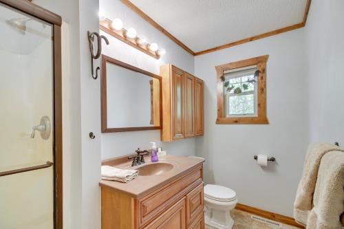a bathroom with a sink and a toilet and a mirror at Minnesota Cabin with Deck and Private Beach in Merrifield