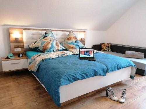 a bedroom with a bed with a laptop on it at Ferienhaus Helene in Hasselfelde