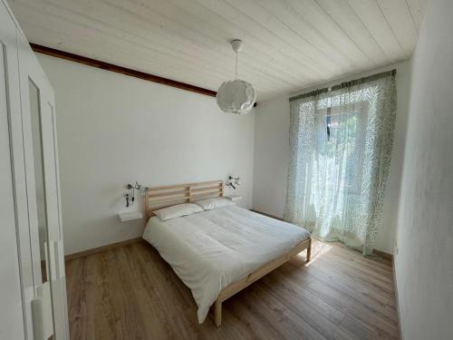 Habitación pequeña con cama y ventana en CASA n 61 en Dervio