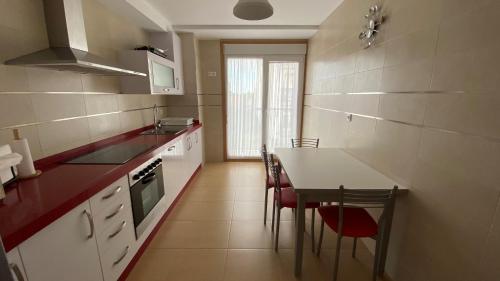 a small kitchen with a table and chairs in it at A Segunda Ronda in Melide