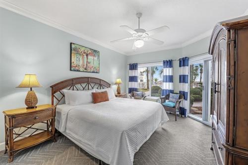 ein Schlafzimmer mit einem Bett und einem Tisch mit einer Lampe in der Unterkunft Palm Beach Resort 15B in Gulf Shores