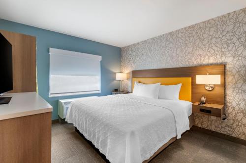 a bedroom with a large bed and a window at Home2 Suites by Hilton Bangor in Bangor