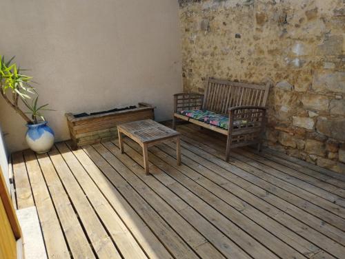 勒芒的住宿－Maisonnette en plein centre ville，一间铺有木地板的客房,配有2张长椅和一张桌子