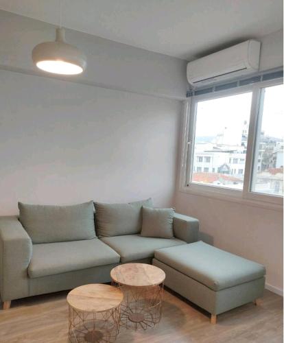 ein Wohnzimmer mit einem Sofa und 2 Tischen in der Unterkunft Antelope Studio 2 in Thessaloniki