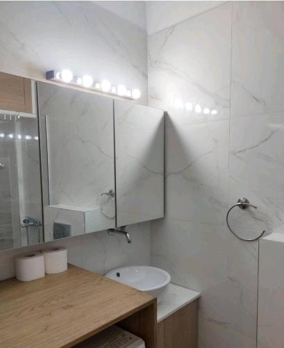 a white bathroom with a sink and a mirror at Antelope Studio 2 in Thessaloniki