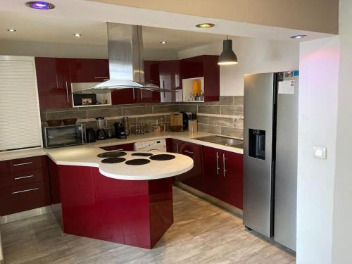 a kitchen with red cabinets and a white counter top at Chez Matthieu in Lannemezan