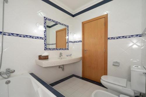 a bathroom with a toilet sink and a mirror at Oceano Azul in Porto Santo