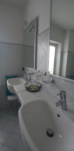 a bathroom with two sinks and a mirror at La casa delle fate in Lusevera