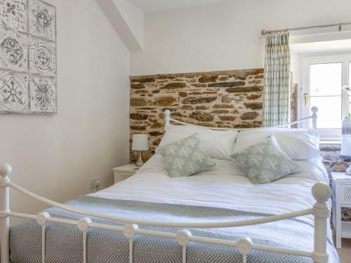 um quarto com uma cama branca e 2 almofadas em Sandpiper Cottage em Salcombe