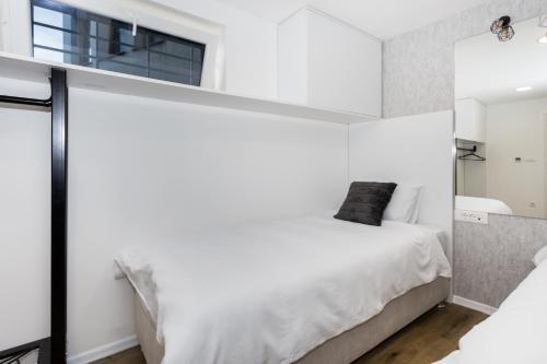 萨拉热窝Royal Grey Apartment的一间卧室，有一张白色的床和一扇窗户