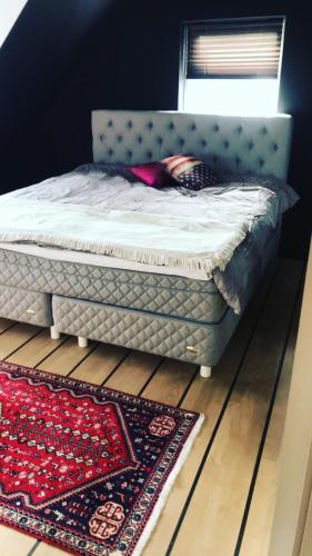 uma cama num quarto com um tapete no chão em Split em Veberöd