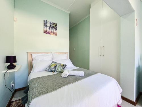 um quarto com uma cama branca com uma toalha em H G Deluxe Guest suites 1 em East London