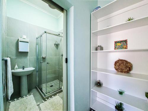 uma casa de banho com um chuveiro e um lavatório. em H G Deluxe Guest suites 1 em East London
