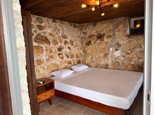 a bedroom with a bed in a stone wall at bacalar My Love Front Laguna in Bacalar