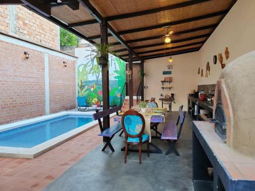 eine Terrasse mit einem Tisch und Stühlen neben einem Pool in der Unterkunft Casa Tesoro Selva in Tarapoto