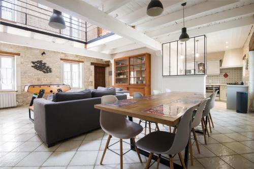 une salle à manger avec une table et un canapé dans l'établissement MACÉDOCY Maison de charme au cœur du Village, à Sainte-Marie de Ré