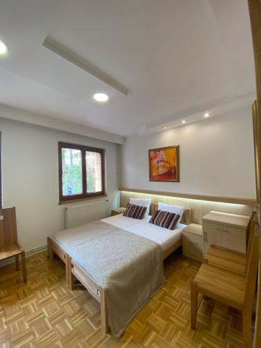 a bedroom with a large bed and a window at Hotel Berr in Sarajevo