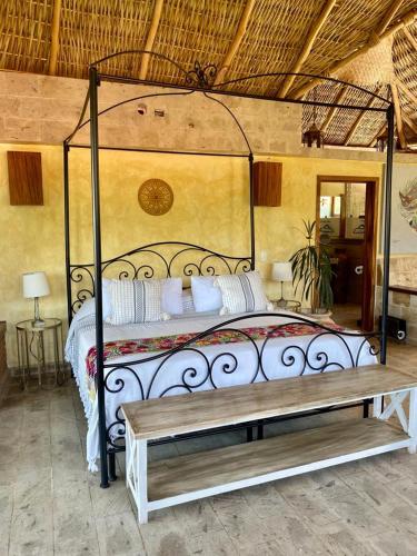 a bedroom with a canopy bed with a bench at Casa Miura Hotel Boutique in Ajijic