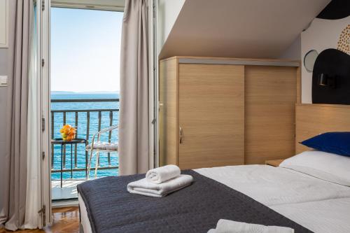 a bedroom with a bed and a view of the ocean at Solar Beach Inn in Split