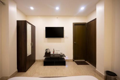a hotel room with a television and a bathroom at Lakeside Suites in Kolkata