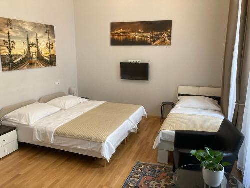 a bedroom with two beds and a flat screen tv at Anabelle Bed and Breakfast in Budapest