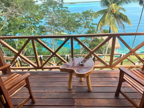 a bench on a wooden deck with a view of the ocean at bacalar My Love Front Laguna in Bacalar