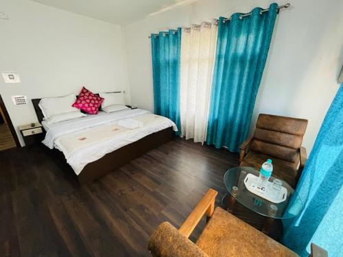 a bedroom with a bed and a chair and a table at Himalayan Haven in Srinagar