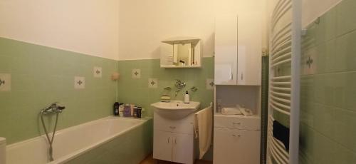 y baño con bañera, lavamanos y bañera. en Rodinný apartmán u Broumovského náměstí en Broumov
