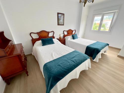 a bedroom with two beds and a window at Apartamentos Sinás Playa in Raxó
